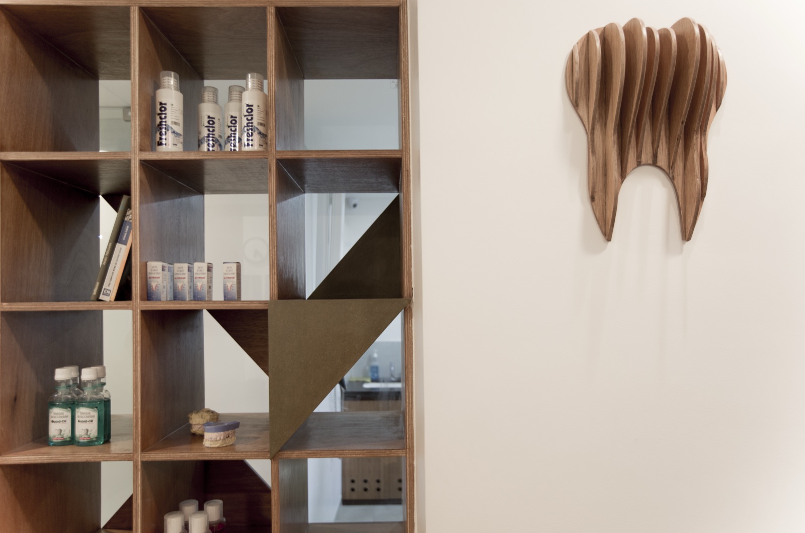 Bespoke wooden cube display shelving with a carved timber wall sculpture by WOODWORKS Interior, Bengaluru