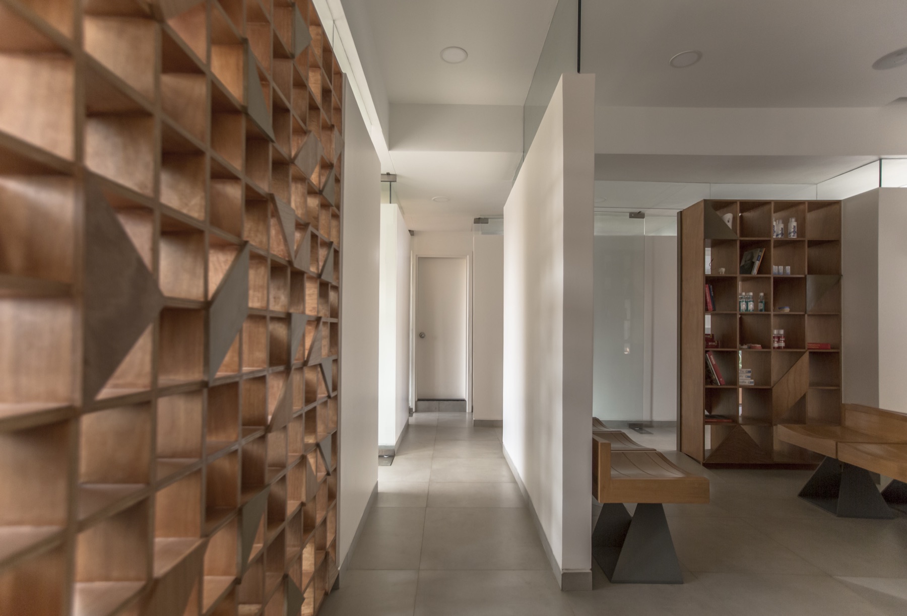 Hand-cut geometric wooden jali screen wall with an integrated bench by WOODWORKS Interior, Bengaluru